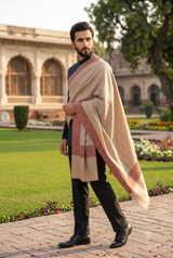 Full view of men's fawn beige wedding dushala draped over ethnic attire in a palace courtyard.