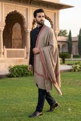 Close-up of fine terracotta rust floral needlework border on a men's luxury beige Pashmina wedding shawl.