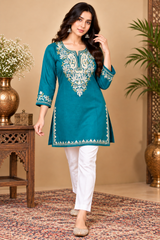 Turquoise blue embroidered kurti styled with white trousers