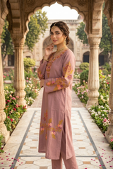 Side view of model in a dusty mauve Kashmiri phiran showing detailed floral embroidery along the sleeve and hemline.